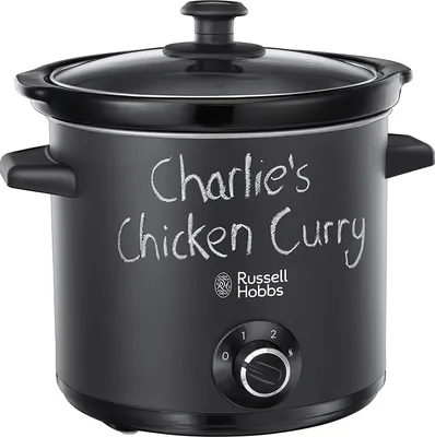 A black slow cooker with "Charlie's Chicken Curry" written on it in chalk.