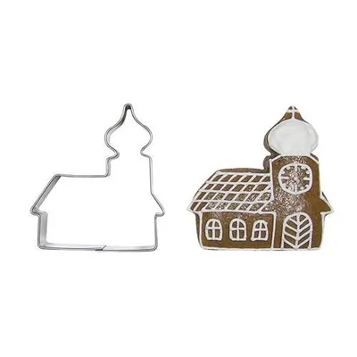 A metal cookie cutter shaped like a church and a gingerbread cookie made with the cutter.