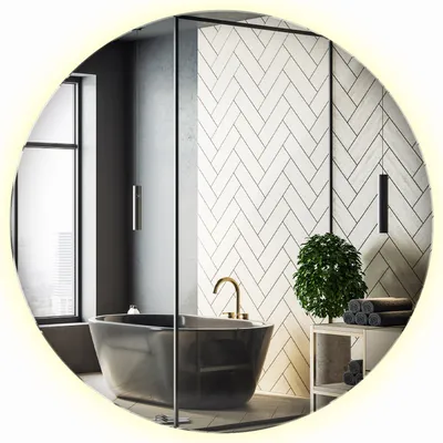 A modern bathroom with a freestanding bathtub, herringbone tile wall, and a round LED mirror.