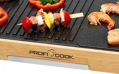 A close-up shot of a teppanyaki grill with food being cooked on it.