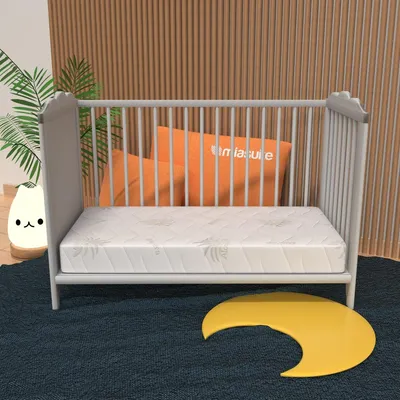 A baby crib with a mattress and pillows.