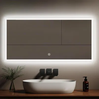 A modern bathroom vanity with a large LED mirror, a sink, and a soap dispenser.