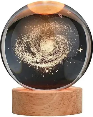 A crystal ball with a galaxy design inside, resting on a wooden base.