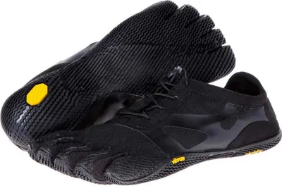 A pair of black Vibram FiveFingers KSO EVO shoes are shown against a white background. One shoe is laid flat with the sole facing up, showing the individual toe compartments and the yellow Vibram logo. The other shoe is upright, displaying the lacing syste