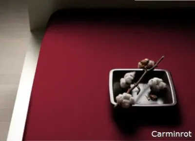 A close-up shot of a red fabric with a small metal tray containing cotton branches.