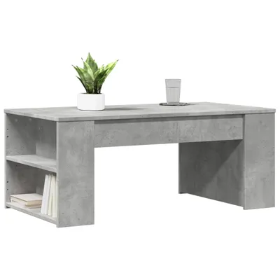 A modern, minimalist coffee table with a concrete-like finish, shown against a plain white background. It features a shelf on one side and a hollow space underneath.