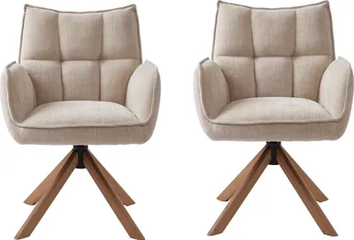 Two beige armchairs with wooden bases on a white background.