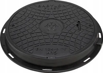 A black manhole cover with a textured surface and embossed text and a logo.