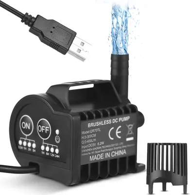 A black USB water pump with water spraying from the top, shown against a white background. A USB cable is visible at the top left.