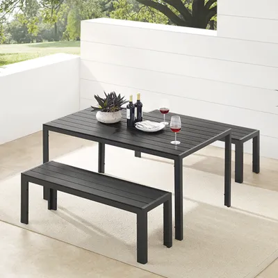 An outdoor dining set with a table and two benches on a patio.