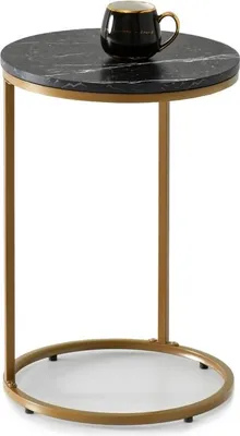A small round side table with a black marble top and gold metal legs, with a black mug on top.