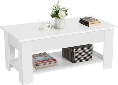 A white coffee table with a lift-top surface, displaying books, a teacup, and a vase of flowers on top, and magazines and a storage box on the lower shelf.