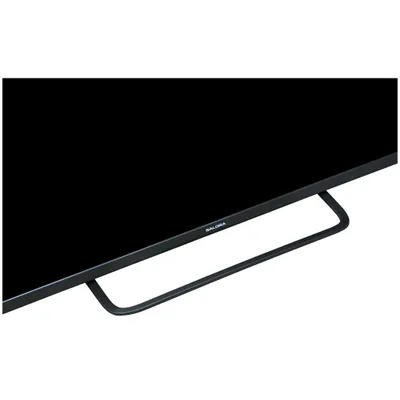 Close-up of the bottom part of a black television with its stand.