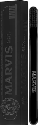A black Marvis toothbrush and its packaging are displayed against a white background.