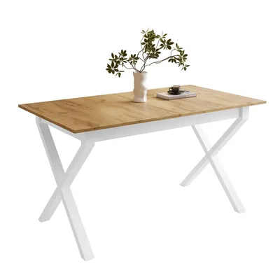 A dining table with a wooden top and white X-shaped legs, decorated with a vase of plants and a book.