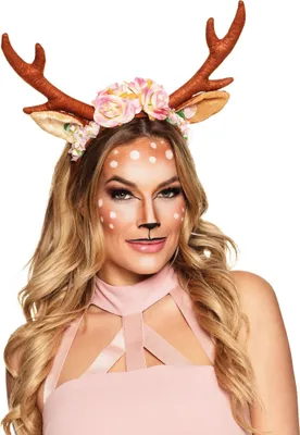 A woman wearing a deer costume headband with antlers and flowers, and deer makeup.