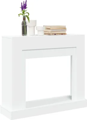 A white fireplace surround with decorative items on top.
