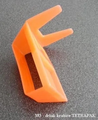 An orange plastic holder for a Tetra Pak box is shown on a gray textured surface.