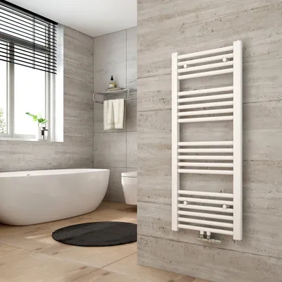 A modern bathroom with a white bathtub, toilet, and a white towel warmer mounted on a textured gray wall.