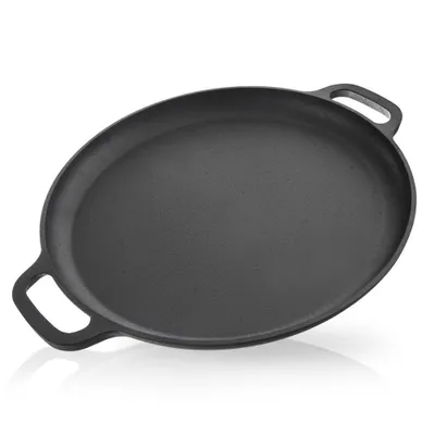A black cast iron pan with two handles is shown from a slightly elevated angle against a white background.