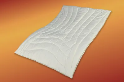 A white duvet is laid out on an orange and yellow gradient background.