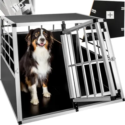 A dog is sitting inside a metal dog crate with the door open.
