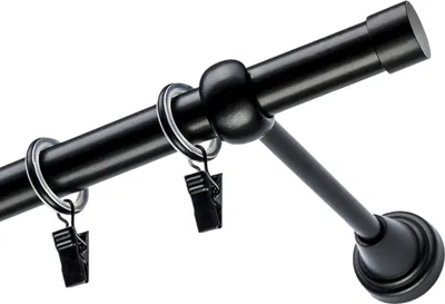 A close-up view of a black curtain rod with rings and clips.