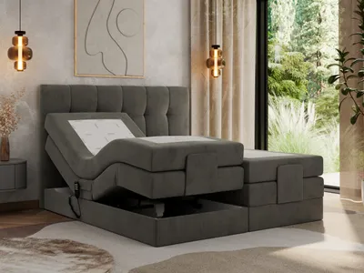 A dark gray upholstered bed with an adjustable mattress is shown in a bedroom setting with a large window overlooking a garden.