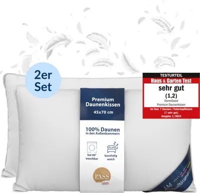 Two white pillows are shown, one slightly behind the other, with feathers floating around them. A product label is attached to the front pillow, and a review badge is in the top right corner.