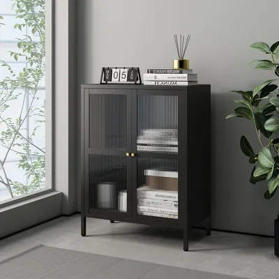 A black sideboard with fluted glass doors is placed in a room with a large window and a plant.