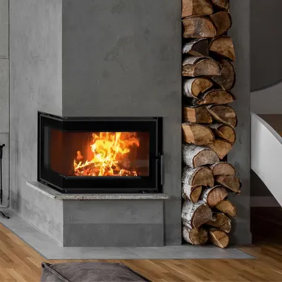 A modern fireplace with a stack of firewood next to it.