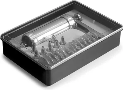 A cookie press set in a black plastic container with a clear plastic lid.
