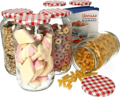 A set of glass jars with red and white checkered lids, filled with various food items like cereal, marshmallows, and pasta. A box with German text is also visible in the background.