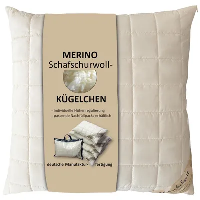 A cream-colored quilted pillow with a beige label attached to the front.