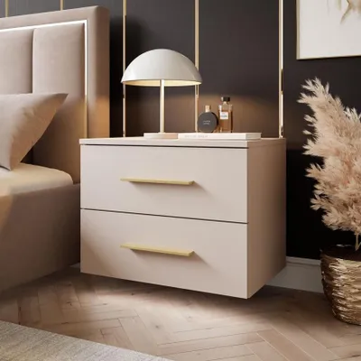 A bedroom scene featuring a bedside table with a lamp and decorative items.