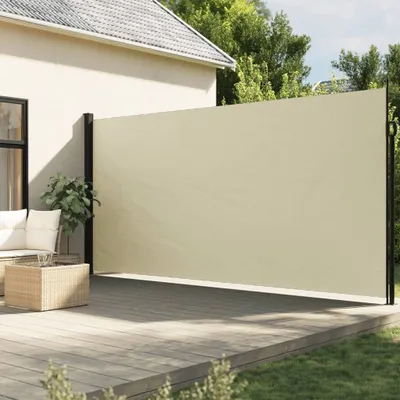 A beige retractable side awning is installed on a wooden deck next to a house, providing shade and privacy. Outdoor furniture and a coffee table are visible on the deck.