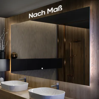 A modern bathroom vanity with two sinks and a large illuminated mirror. The mirror has text at the top and reflects a shower area.