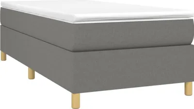 A studio shot of a boxspring bed frame with a mattress on top.