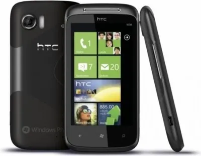 A black HTC smartphone is shown from the back and side, with its screen displaying the Windows Phone interface.