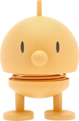 A front view of a small, yellow, spring-loaded toy figure against a white background.
