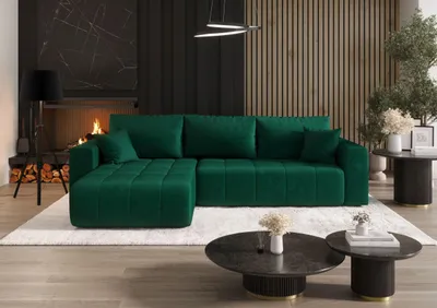 A luxurious green sectional sofa is placed on a plush white rug in a modern living room with a fireplace and wooden accent wall.