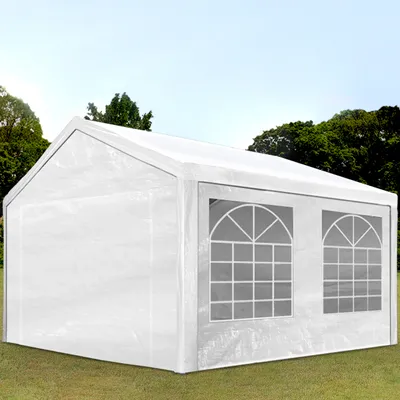 A white party tent with arched windows is set up on a grassy lawn with trees and a blue sky in the background.