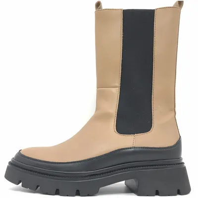 A side view of a beige and black platform boot against a white background.