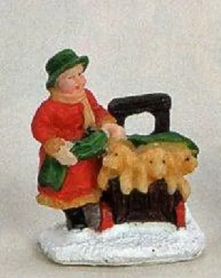 Ein kleines Mädchen, das einen Korb mit Welpen trägt. Die Figur strahlt Wärme und Heiterkeit aus.
