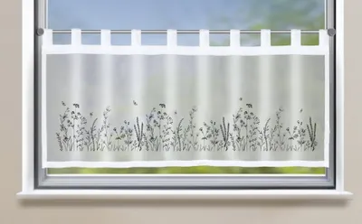 A sheer cafe curtain with a floral design is shown hanging in a window.