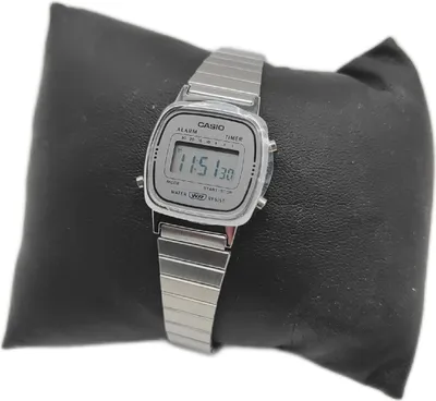 A digital watch displayed on a black cushion.