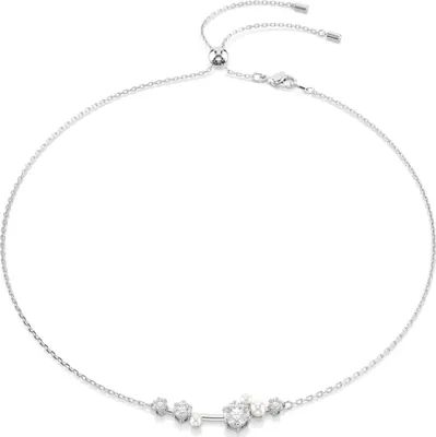 A silver necklace with clear stones on a white background.