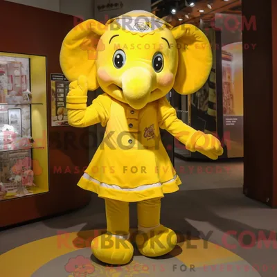 Productafbeelding van Mascottefiguur REDBROKOLY van een gele olifant gekleed met een minirok en hoofdbanden