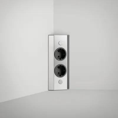 A corner of a room with a wall-mounted electrical outlet.