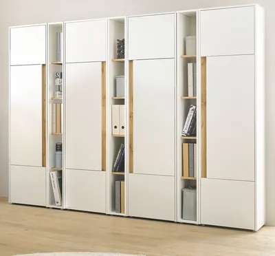 A white and wood-colored shelving unit with books and binders.